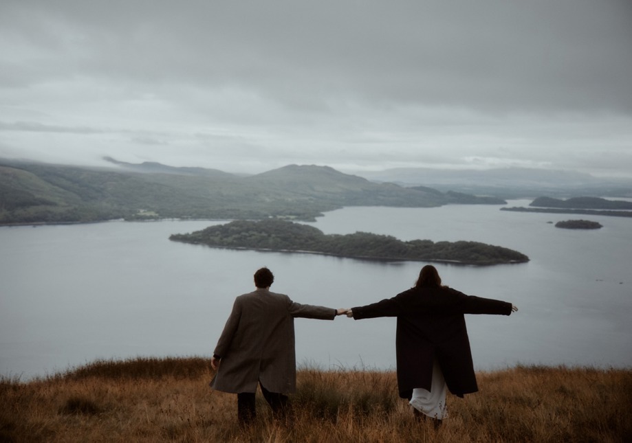 A couple holding hands on a mountain in Loch Lomond, Scotland